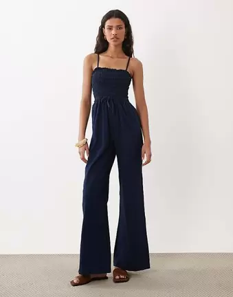 ASOS DESIGN – Gesmokter Jeans-Jumpsuit in tintenblauer Waschung