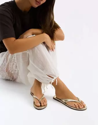 Bershka – Flache Zehenstegsandalen in Goldoptik