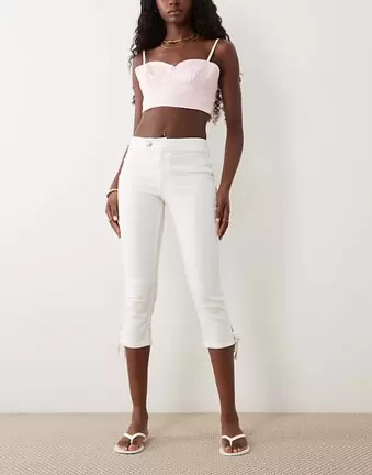 Miss Selfridge – Jeans-Caprihose in cremefarbener Waschung mit Schleifen