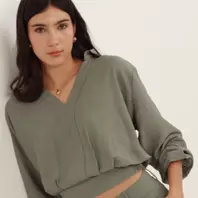 Blusa crop cuello sport manga larga con hiladillo y ajuste en cintura