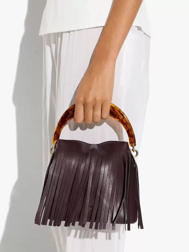 Handbag with fringes with rigid handle